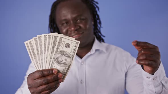 African Man Holding Money in His Hand and Pointing on It with Finger