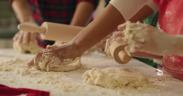 Handheld view of family rolling the dough for Christmas cookies