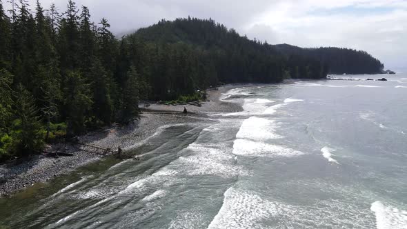 Aerial footage in 4k of Sombrio beach on a cloudy summer day. Big waves crashing on the shore and a