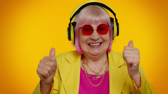 Senior Woman Listening Music on Headphones Dancing Disco Fooling Having Fun Gesticulating Hands