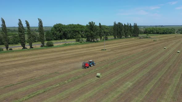 A Round Baler Discharges a Fresh Wheat Bale During Harvesting