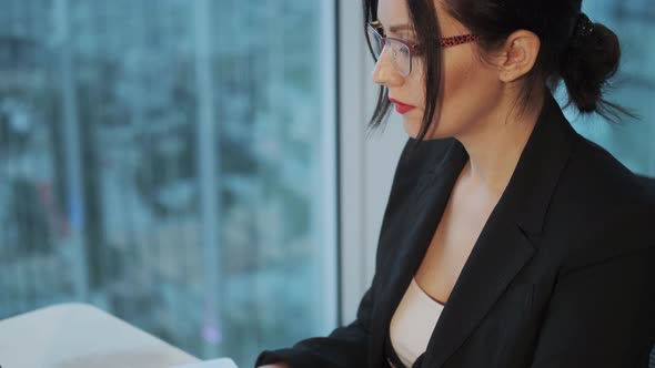 Portrait of a Young Business Woman Working at a Computer in a Modern Office