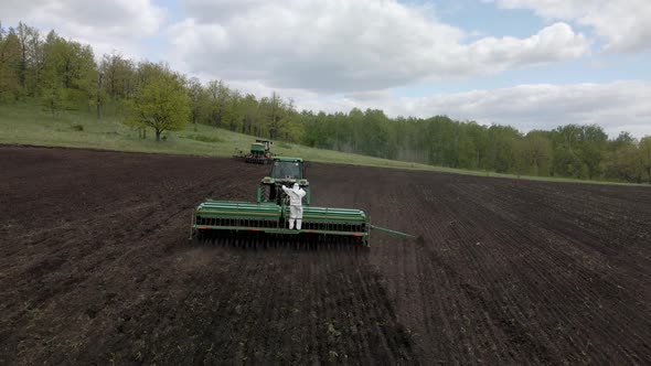 Agricultural tractor in the field fluff the earth.