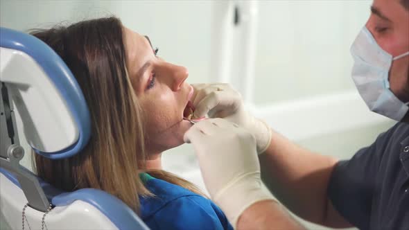 Orthodontist Examines with the Help of Mirror the Oral Cavity of a Young Patient