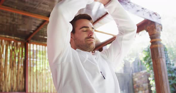 Caucasian man practicing yoga and meditating at vacation home