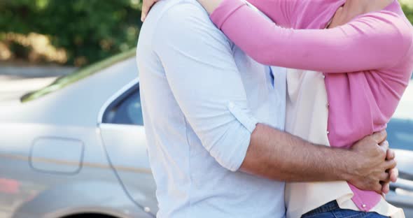 Couple interacting with each other near car