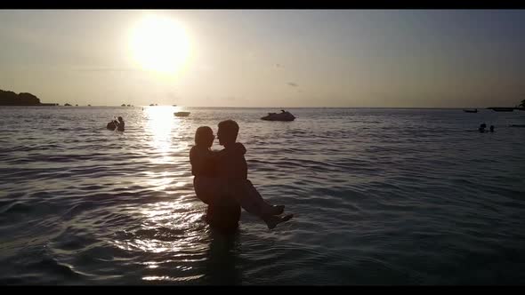 Two people posing on tropical island beach journey by clear water and white sand background of the M