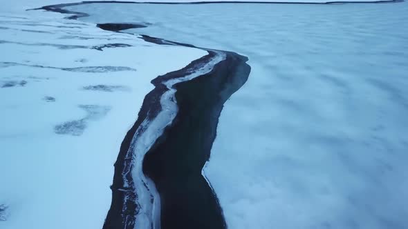 Frozen Landscape of a Icy River Found in the Snowy Mountains in Switzerland, Aerial