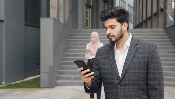 Successful Arabian Business Partners Using Personal Cell Phones Near Office