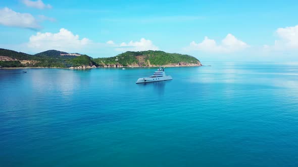 Aerial flying over panorama of exotic lagoon beach wildlife by blue water and white sand background 