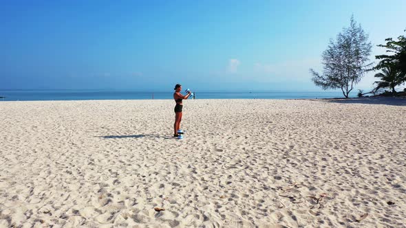 Pretty fun women on holiday in the sun on beach on sunny blue and white sand 4K background