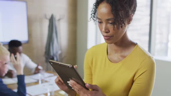 Portrait of happy african american businesswoman with tablet in creative office