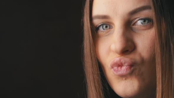 Face of a Beautiful Young Woman Sending a Kiss