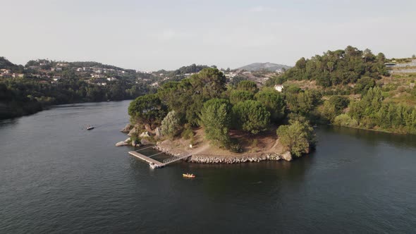 Beautiful small pier near Island of Love in Castelo De Paiva, aerial orbit view