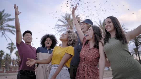 Slow Motion of an Multiethnic Group of Young People Having Fun with Confetti Outside