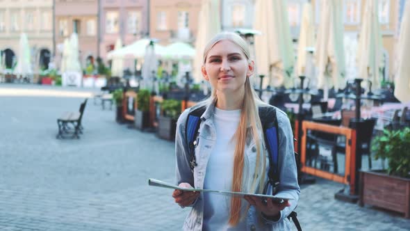 Zoom Shot of Trendy Tourist with Map Smiling to the Camera