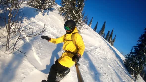 Professional snowboarder creating snow cloud riding on snowboard. Rider having fun doing tricks