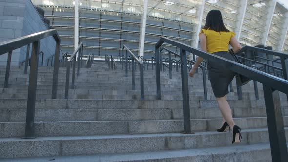 Business Woman Walking Up Stairs To Office Center