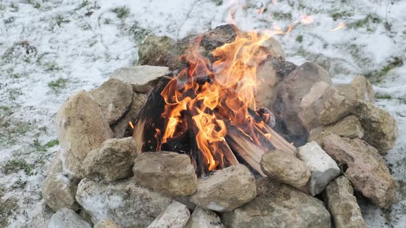 Close Up of a Fire on the Snow Near the Mountain Stream in the Winter Forest