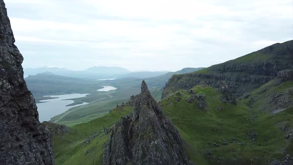 advance drone shot between old man of storr rock formations in isle of skye scotland. Green mountain