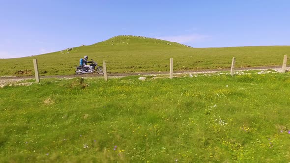 Motorcyclist driving his motorbike on the mountain road in the mountain country side.