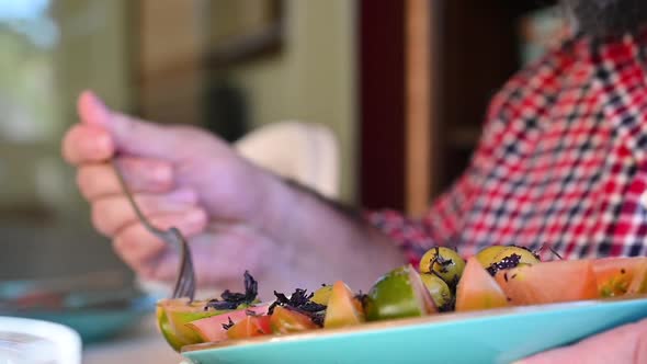 Man Putting Salad on Plate at Home