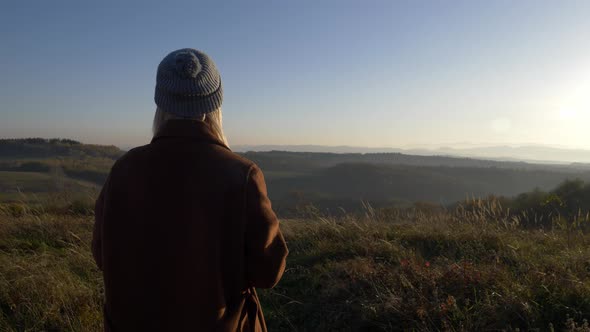 woman hold mug of tea in mountains Sudetes in November in sunset