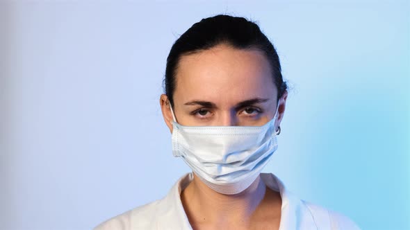 Female Nurse Putting on Mask and Medical Cap