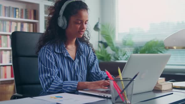 Young Indian Woman Music Lover Works and Listens to Music on Headphones