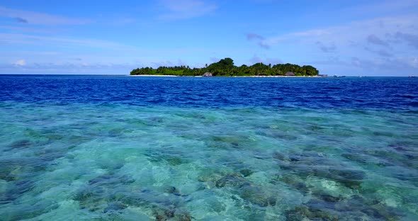 Natural fly over tourism shot of a sandy white paradise beach and aqua blue ocean background in high