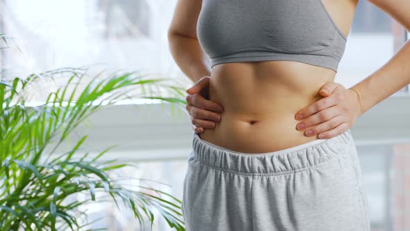 Woman Compressing the Skin on Her Stomach and Sides Checking for Excess Subcutaneous Fat