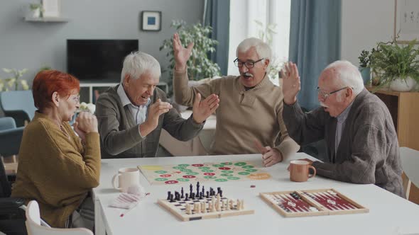 Happy Seniors Playing Board Game Together