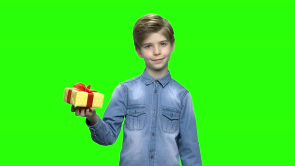 Boy in Denim Jacket Holding Yellow Gift Box and Pointing Finger