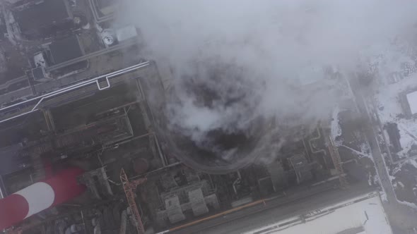 Smoking Factory Chimney Against the Background of Big Industrial City Covered with Snow alt
