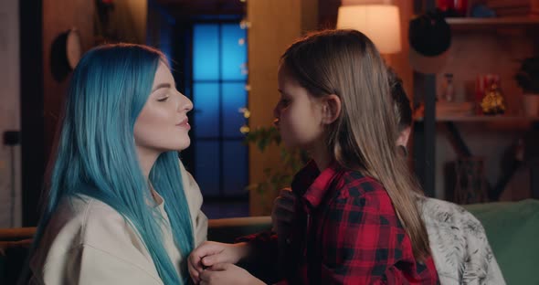 Millennial Blue Haired Woman and Her Pretty Daughter Giving Each Other Kiss While Having Fun and