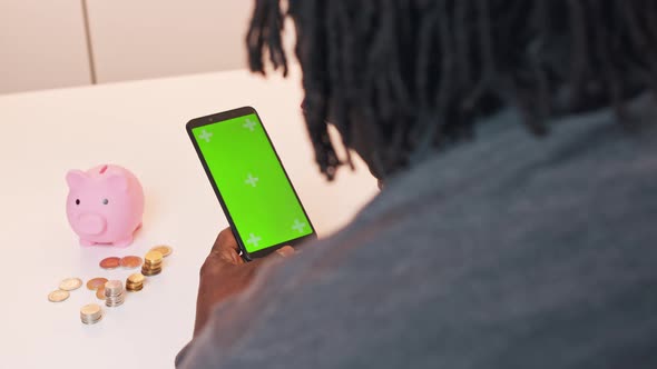 African American Man Using Phone App To Manage His Investments