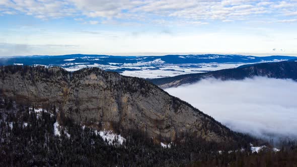 Hyperlapse of clouds passing beneath mountains in Creux du Van, Switzerland