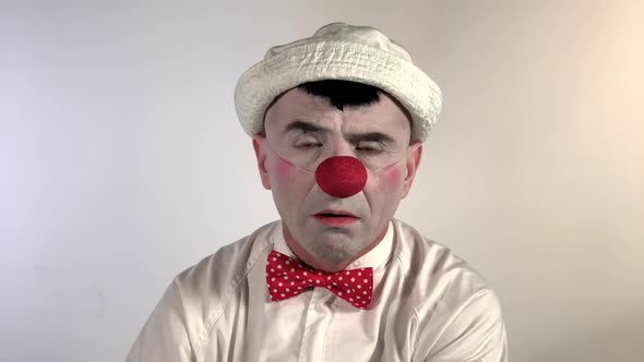 Emoji Clown. A clown mime with a pouting face outwardly showing displeasure with a person or situati