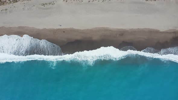 Aerial view sandy beach with white waves