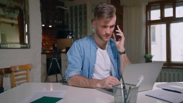 Handsome Male Freelancer Talking on the Phone with Smile at Home with Laptop Computer Spbas
