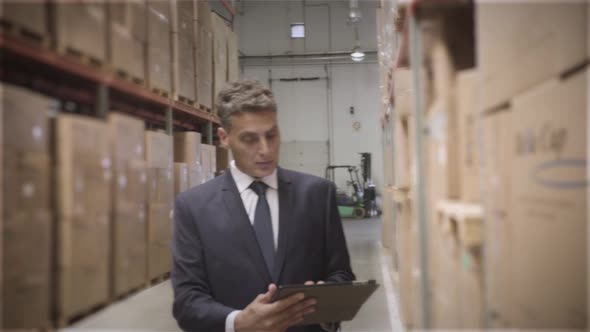Businessman with digital tablet in warehouse