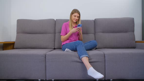 Happy blonde woman typing message on social media app on mobile phone in 4k stock video