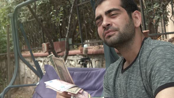 Young Man Chilling With Money In Hands