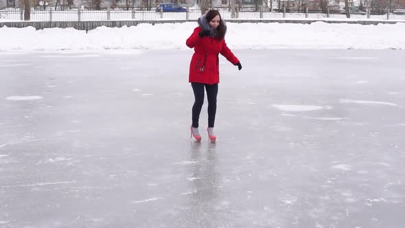 Young Woman in Winter Clothes and Highheeled Shoes Glides on Ice