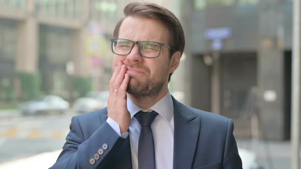 Portrait of Businessman having Toothache, Cavity Outdoor