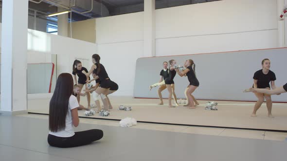 Girls Practicing Cheerleading Stunt during Practice