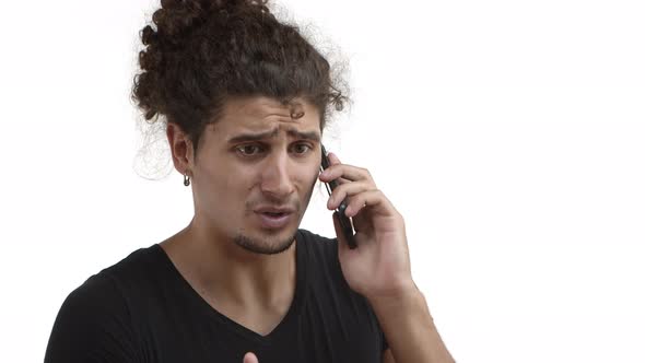 Closeup of Serious Handsome Guy with Beard and Curly Hair Explain Something During Phone Call