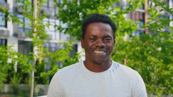 Close Up Smiling Afroamerican Man Looks Camera on Background Modern Building