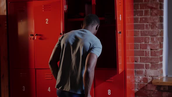 Africanamerican Athletic Young Man Changing in the Locker Room