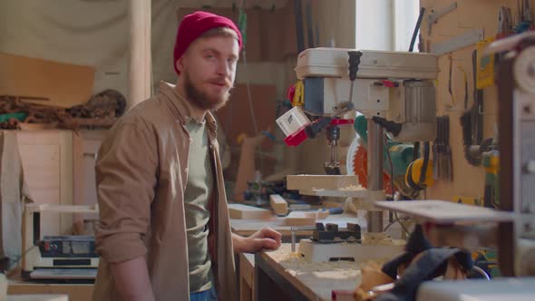 Carpenter Posing for Camera in Woodworking Workshop